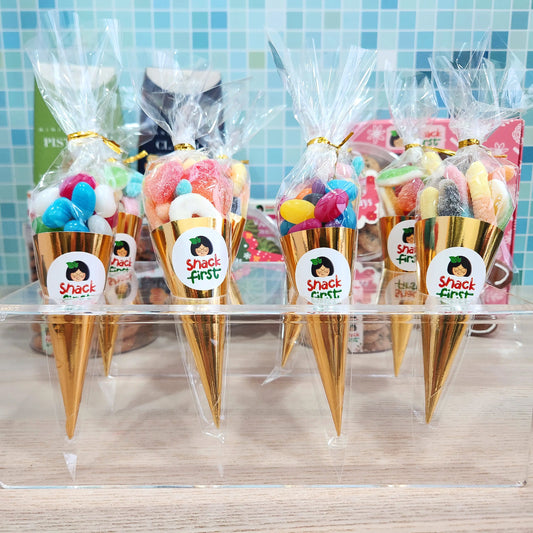Cones filled with colorful candy and 'Shack First' labels on a tiled wall background.